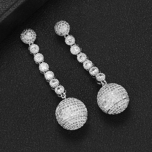 Silver beaded earrings on a black background